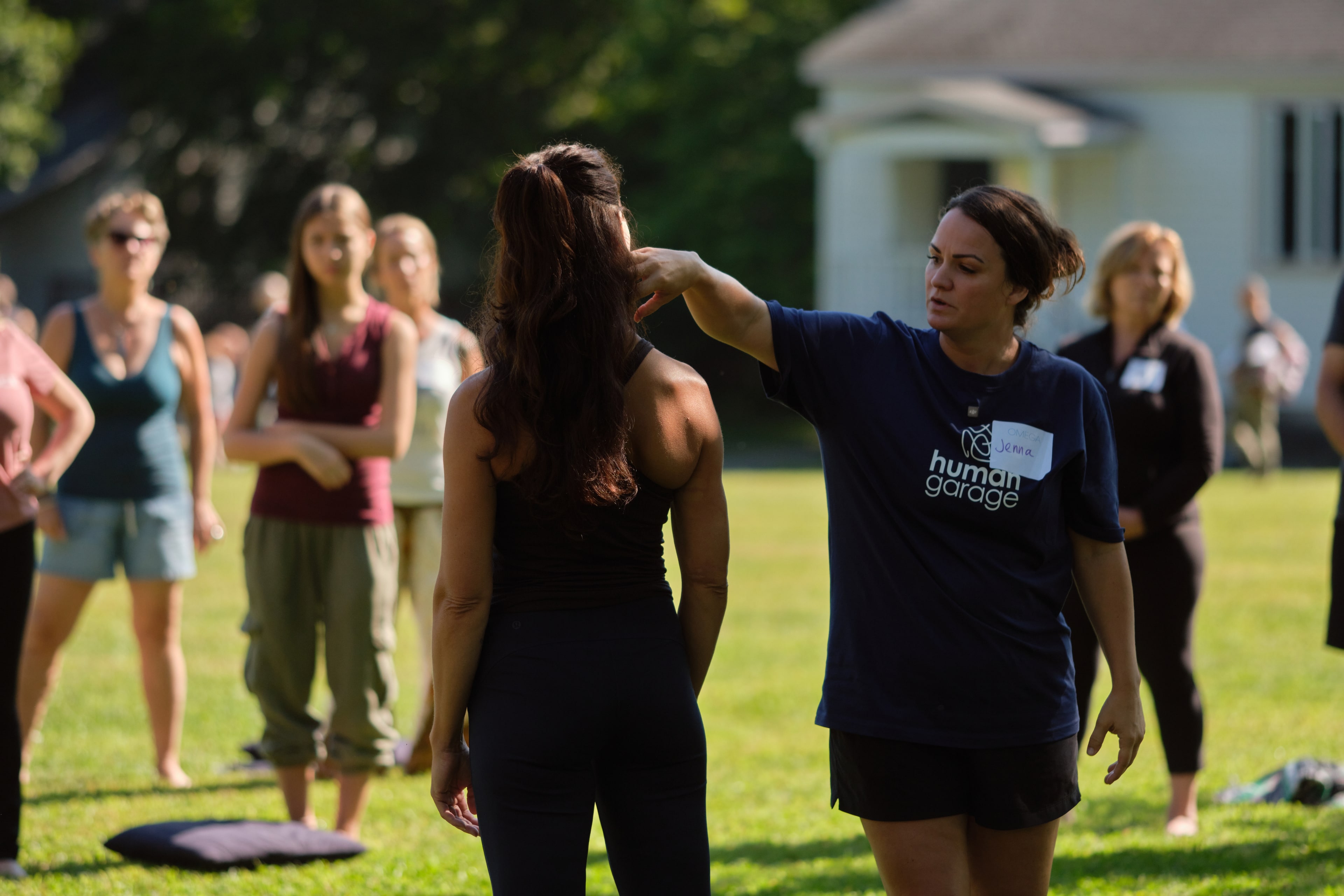 Coach demonstrating a fascial movement outdoors among olive trees